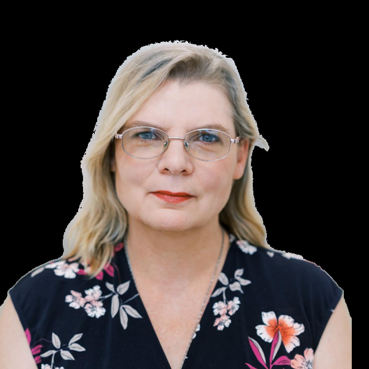 Professional headshot of a female healthcare practitioner wearing glasses and floral top