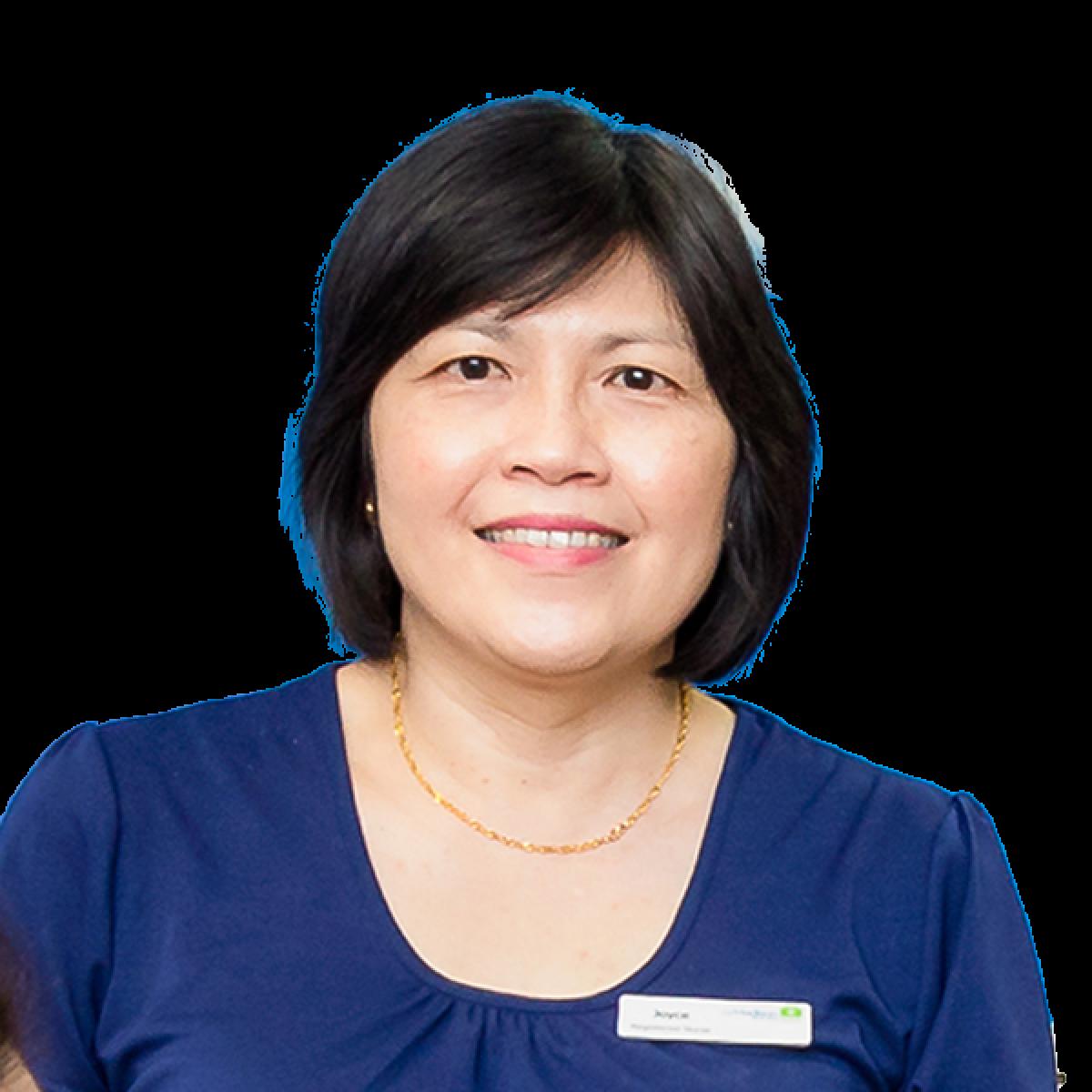 Professional headshot of female healthcare practitioner in blue medical uniform smiling at camera