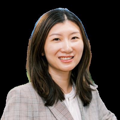 Professional female doctor smiling warmly in grey checked blazer against white background