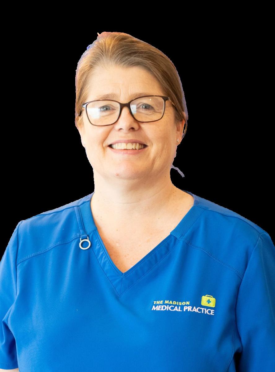 Female healthcare professional wearing blue medical scrubs and glasses, smiling at camera in professional headshot
