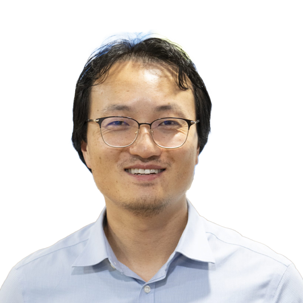 Professional headshot of smiling Asian male doctor wearing glasses and light blue shirt against white background