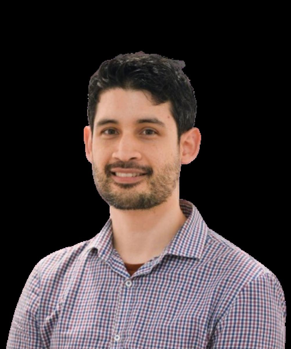 Professional headshot of male healthcare practitioner in checkered shirt smiling at camera