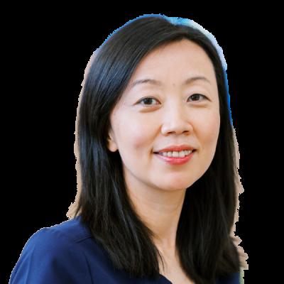 Professional female doctor in navy scrubs smiling warmly at camera against white background