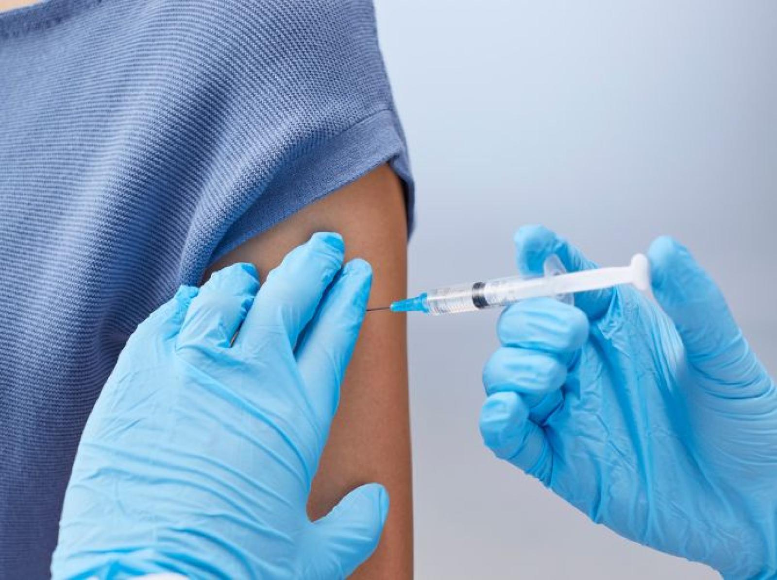 Healthcare worker administering a vaccine injection into a patient’s upper arm