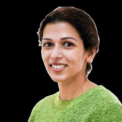 Smiling female healthcare professional wearing a green jumper against a white background