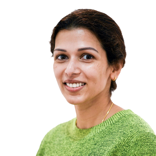 Smiling female healthcare professional wearing a green jumper against a white background