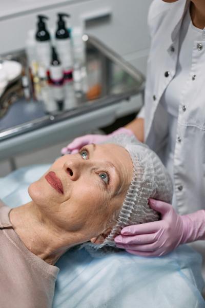 Healthcare professional performing medical skin assessment on mature female patient in clinical setting