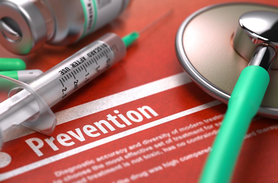 Medical prevention concept with syringe, stethoscope and preventive care documentation on red background
